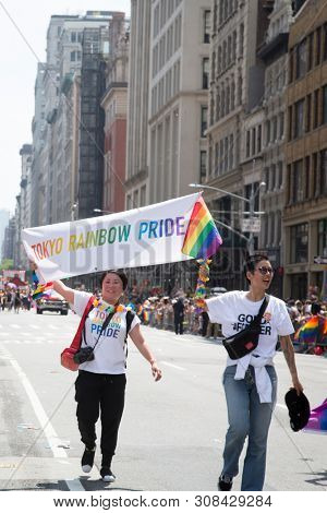 2018 JUNE 24 NEW YORK: NYC Pride March participants walk with a banner that says Tokyo Rainbow Pride on the 5th Ave parade route.