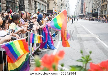 2018 JUNE 24 NEW YORK: NYC Pride March spectators wave rainbow flags and cheer the participants at 23rd St and 5th Ave.