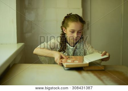 Pupil In School Uniform With Braids. Girl Schoolgirl At School With Book In School Uniform. Training