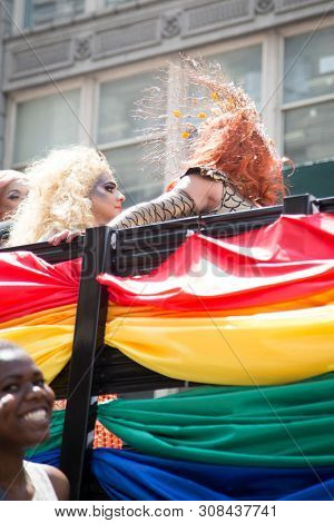 2018 JUNE 24 NEW YORK: NYC Pride March participants ride on a float adorned with rainbow flag material at 23rd St and 5th Ave.