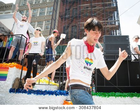 2018 JUNE 24 NEW YORK: NYC Pride March participant dances alongside the iHeart Radio station float along the 5th Ave parade route.