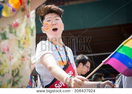2018 JUNE 24 NEW YORK: NYC Pride March participants wave rainbow flags as they walk along the parade route on 5th Ave.