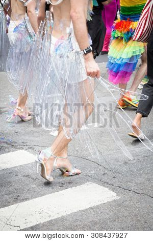 2018 JUNE 24 NEW YORK: NYC Pride March participants wearing a clear plastic winged outfit walks along the 5th Ave parade route.