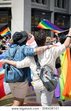 2018 JUNE 24 NEW YORK: NYC Pride March participants wave rainbow flags as they walk along the parade route on 5th Ave.
