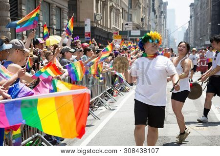 2018 JUNE 24 NEW YORK: NYC Pride March participants play drums for the cheering spectators on the 5th Ave parade route.