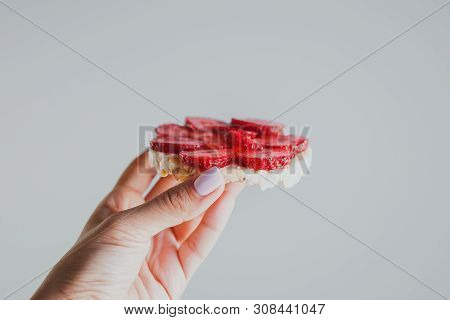 Crispbread With Strawberries In Hand On A Gray Background