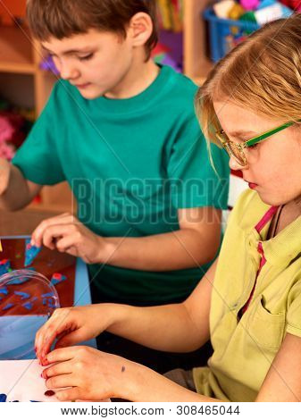 Children model from plasticine in school craft lesson. Arts and crafts group kids in preschooler.