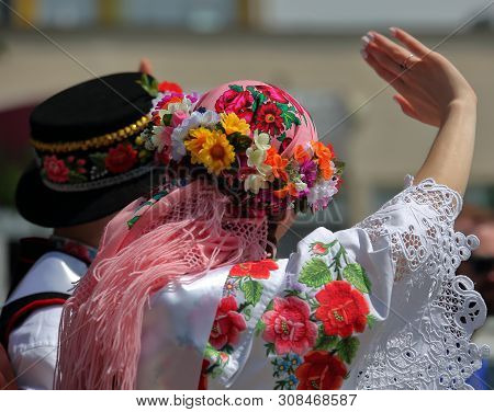 Young Girl And Man On Their Back In Traditional Beautiful Decorative Folk Costumes From Lowicz Regio