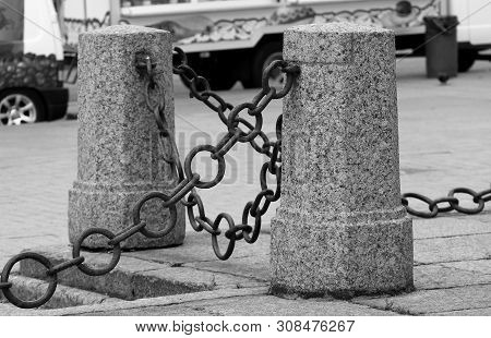 A Fence Of Granite Posts With Iron Chains