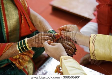Traditional Hindu Marriage Ceremony Where Groom Tides Holy Thread On The Wrist Of Bride.