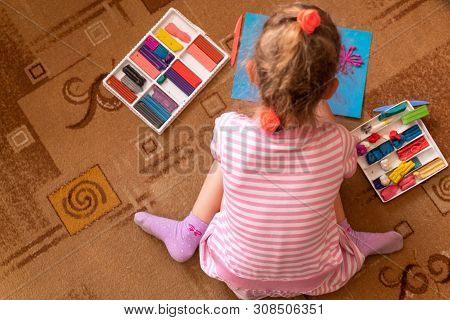 A Little Girl Plays And Sculpts From Clay. Modeling Of Plasticine And The Development Of Fine Motor