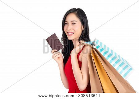 Beautiful Happy Asian Woman Holding Shopping Bags And Showing Passort In Another Hand, Studio Shot I