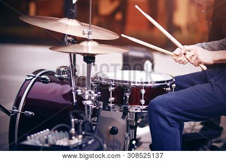 Guy Is A Street Musician In Blue Pants Playing Rhythm On A Beautiful Red Drum Set With Wooden Drumst