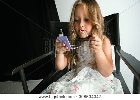 Interaction Of Children With Adult World. Cute Girl Trying To Do Bright Make Up For Being Older. Lit