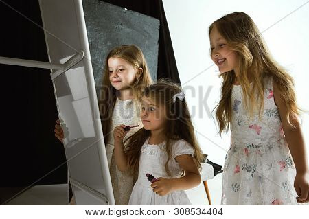 Interaction Of Children With Adult World. Cute Girls Trying To Do Bright Make Up For Being Older. Li