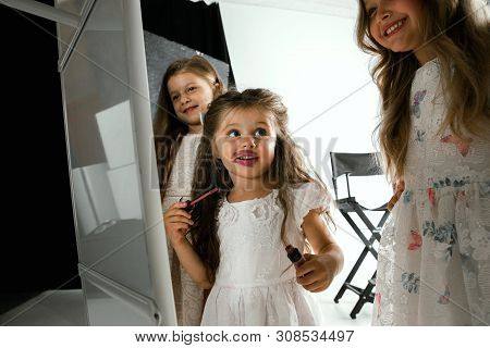 Interaction Of Children With Adult World. Cute Girls Trying To Do Bright Make Up For Being Older. Li