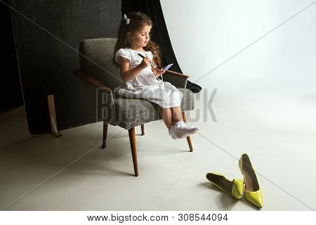 Interaction Of Children With Adult World. Cute Girl Trying To Do Bright Make Up For Being Older. Lit
