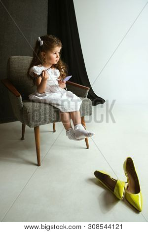 Interaction Of Children With Adult World. Cute Girl Trying To Do Bright Make Up For Being Older. Lit