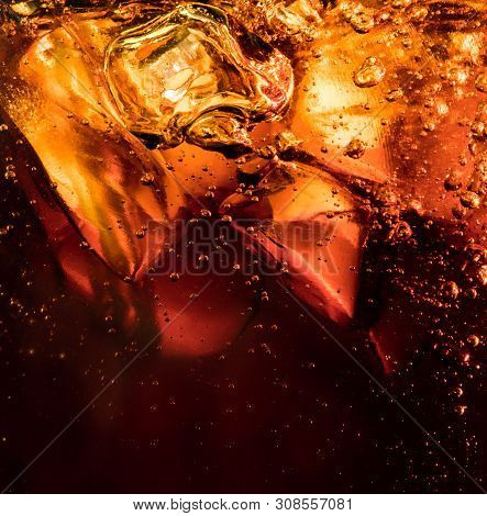 Close Up View Of The Ice Cubes In Dark Cola Background. Texture Of Cooling Sweet Summers Drink With 