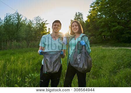 Friends Crouching With Bag Picking Up Trash Doing Plogging.plogging Concept. Boy And Girl Picking Up