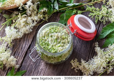 A Jar Filled With Meadowsweet Blossoms And Alcohol, To Prepare Homemade Tincture