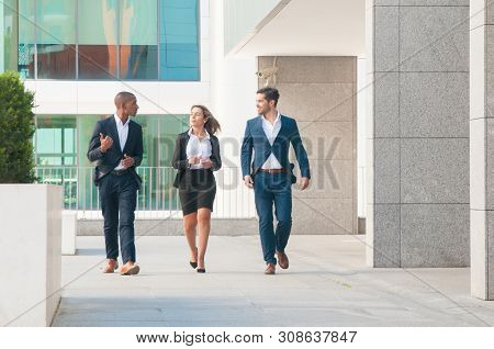 Cheerful Successful Coworkers Talking On Their Way To Office. Business People Walking Outdoors And C