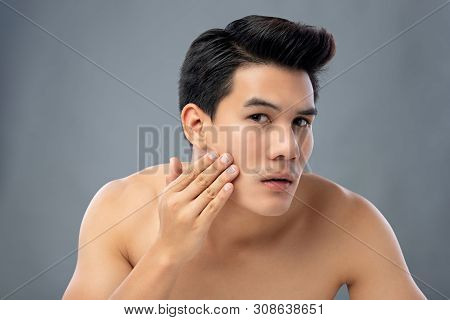Portrait Of Shirtless Young Handsome Asian Man Checking His Face For Skin Care And Beauty Concepts, 