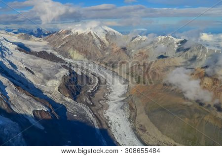 Aerial View Of Alaska Mountaion Range Around Denali Peak From A Plane With Glaciers Around And Blue 