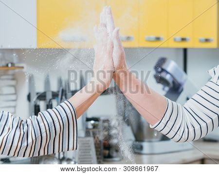 Successful Job In Kitchen. Closeup Of Women Hands Giving High Five, Shacking Off Flour.