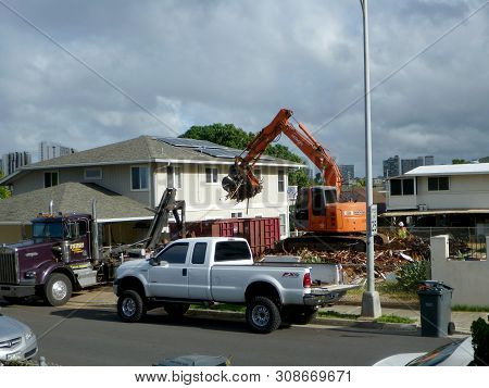 Honolulu - June 24, 2013: Construction Hitachi Bulldozer Tears Down Home And Lots Material Into Truc