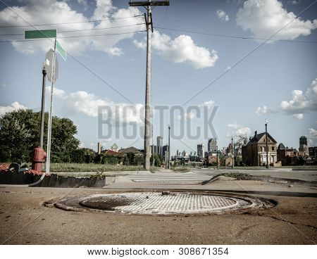 Distressed Detroit neihborhood with many abandoned houses. Downtown skysrapers in the backdrop.