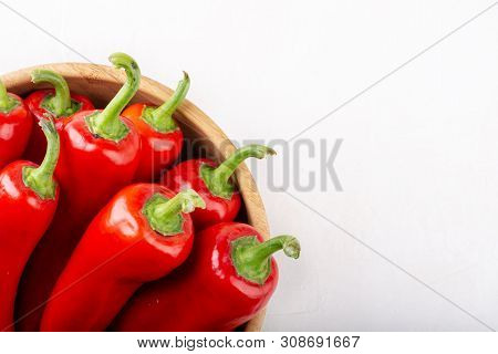 Red Pepper In Wooden Bowl On White Background. Top View, Copy Space, Close-up. Ramiro Pepper.