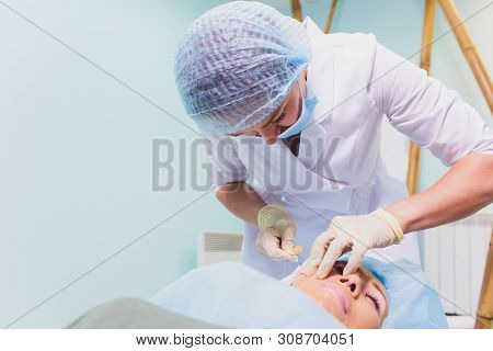 Aged Woman Doing Mesothreads And Thread Lifting, Cosmetology. Cosmetic Procedure To Eliminate Signs 