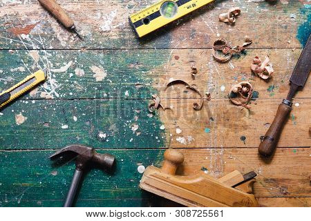 Flat Lay Set Of Vintage Carpentry Tools On Colorful Wooden Background. Top View Workbench With Carpe
