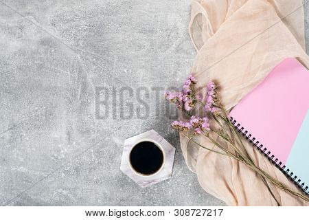 Flat Lay Composition With Feminine Scarf, Coffee Cup, Pink Dry Flowers, Paper Notebook On Concrete S