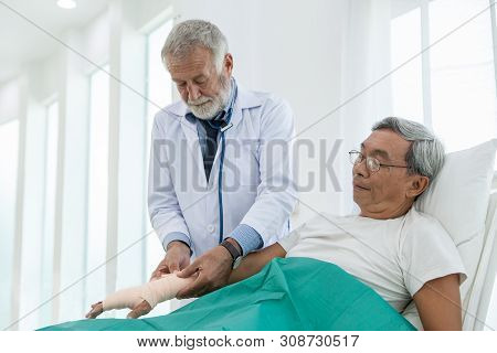 Senior Medical Doctor Bandage Elastic Bandage Hand And Arm Of Old Elderly Patient Lying On Bed In Wa