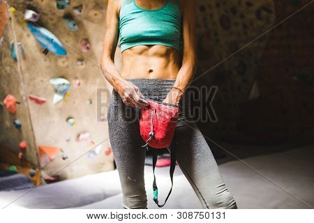 Slender Rock Climber Holds A Bag Of Magnesia. Training On The Climbing Wall. Strong Female Hands. Wo
