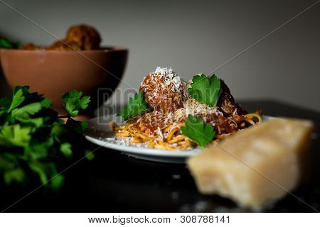 A Close-up Shot Of A Plate Of Rustic Spaghetti And Meatballs With A Bowl Of Meatballs, Parmesean Che