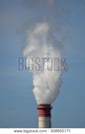 Smoke Up From Industrial Chimney Against Blue Sky