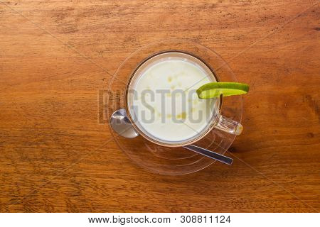 Lemon Yogurt Fresh Milk In A Clear Glass Placed On A Brown Wooden Table With Sea Water Surface Backg