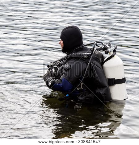 Scuba Diver Enters The Mountain Lake Water. Practicing Techniques For Emergency Rescuers. Immersion 