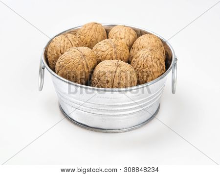 Chrome Metal Bowl With Walnuts Close-up On A White Background. Still Life, Subject Shooting.