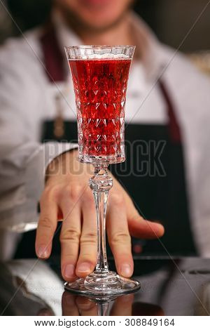 Barmen Is Making Kir Royal Cocktail With Orange Slice And Ice Cubes