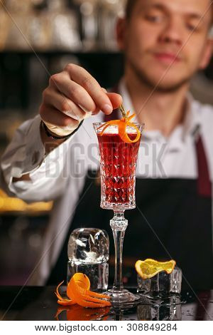 Barmen Is Making Kir Royal Cocktail With Orange Slice And Ice Cubes
