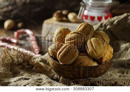 Close-up Of Nuts From Dough, Lying In A Coconut Bowl On A Sack Napkin In Combination With Blurred Ob