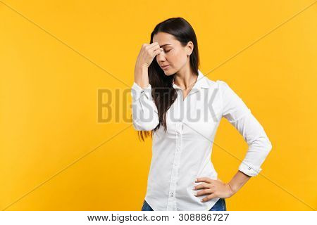 Portrait Of Tired Young Woman In White Casual Shirt Keeping Eyes Closed And Putting Hand On Nose Iso