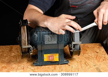 A Man In Working Clothes Hones Professional Sharpening Kitchen Knives