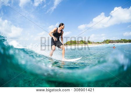 HIMMAFUSHI / MALDIVES - MARCH 08, 2019: Young surfer rides the ocean wave on the Sultans surf spot in Maldives