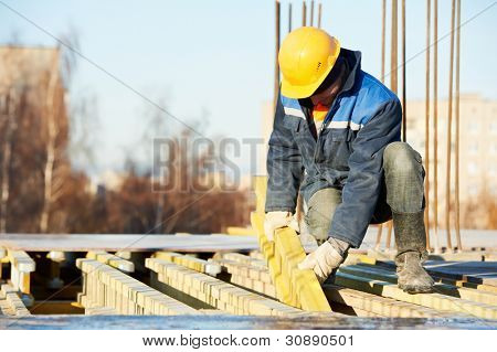 construction worker at construction site assembling falsework for concrete pouring