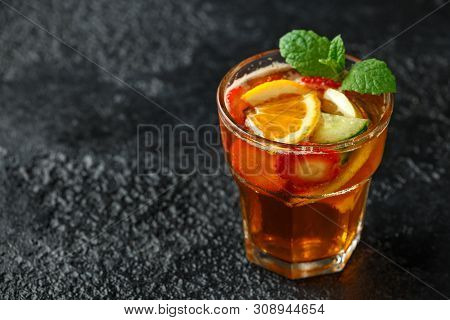 Refreshing Pimms Cocktail With Fruit And Vegetables On Rustic Black Table